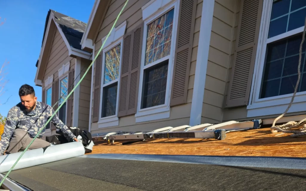 Aspire Roofing crew member installing roof underlayment on a Colorado home